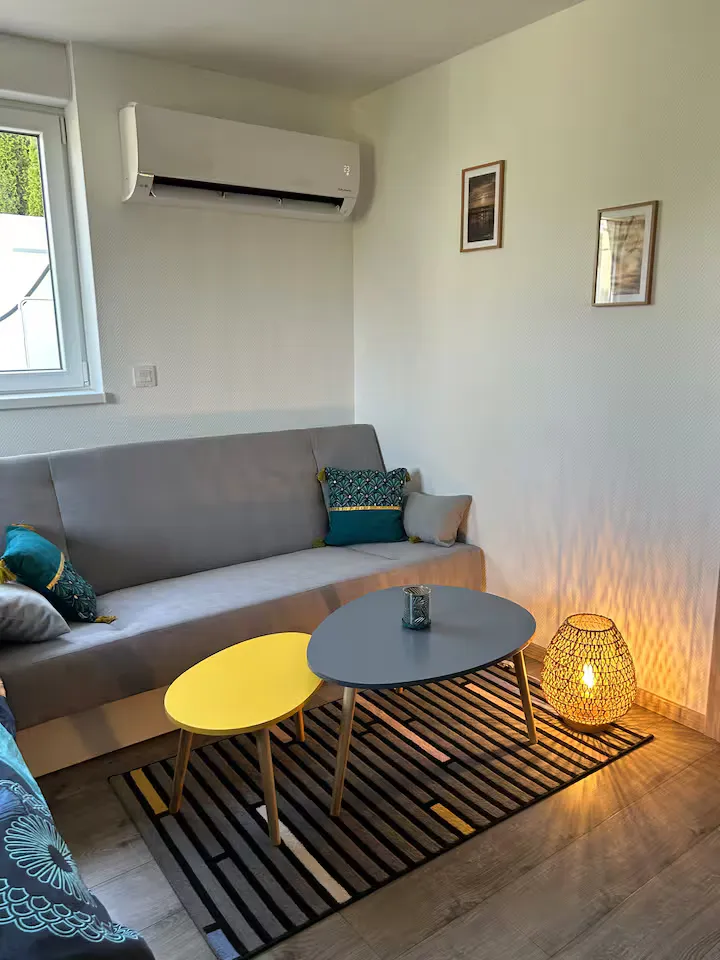 Le coin salon de la Petite Escale à la tombée du jour, lampe allumée